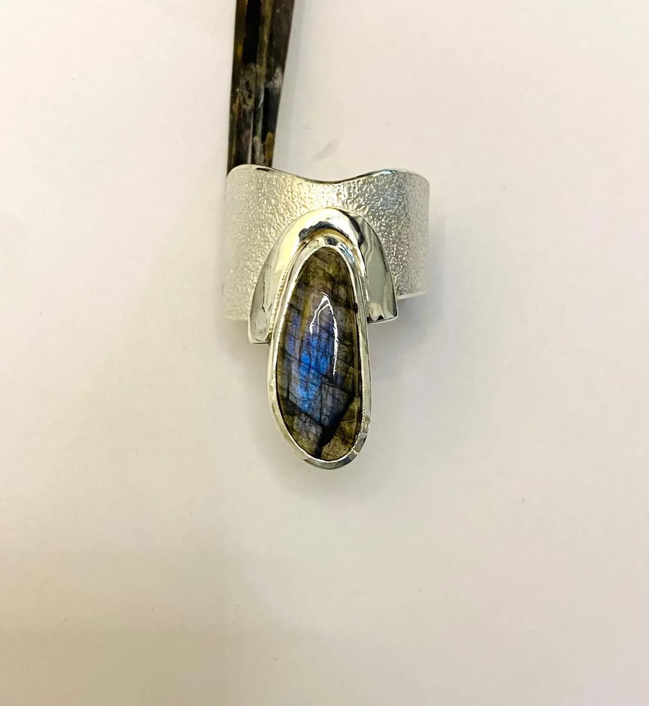 Ring with a large, lustrous stone on a ring mandrel