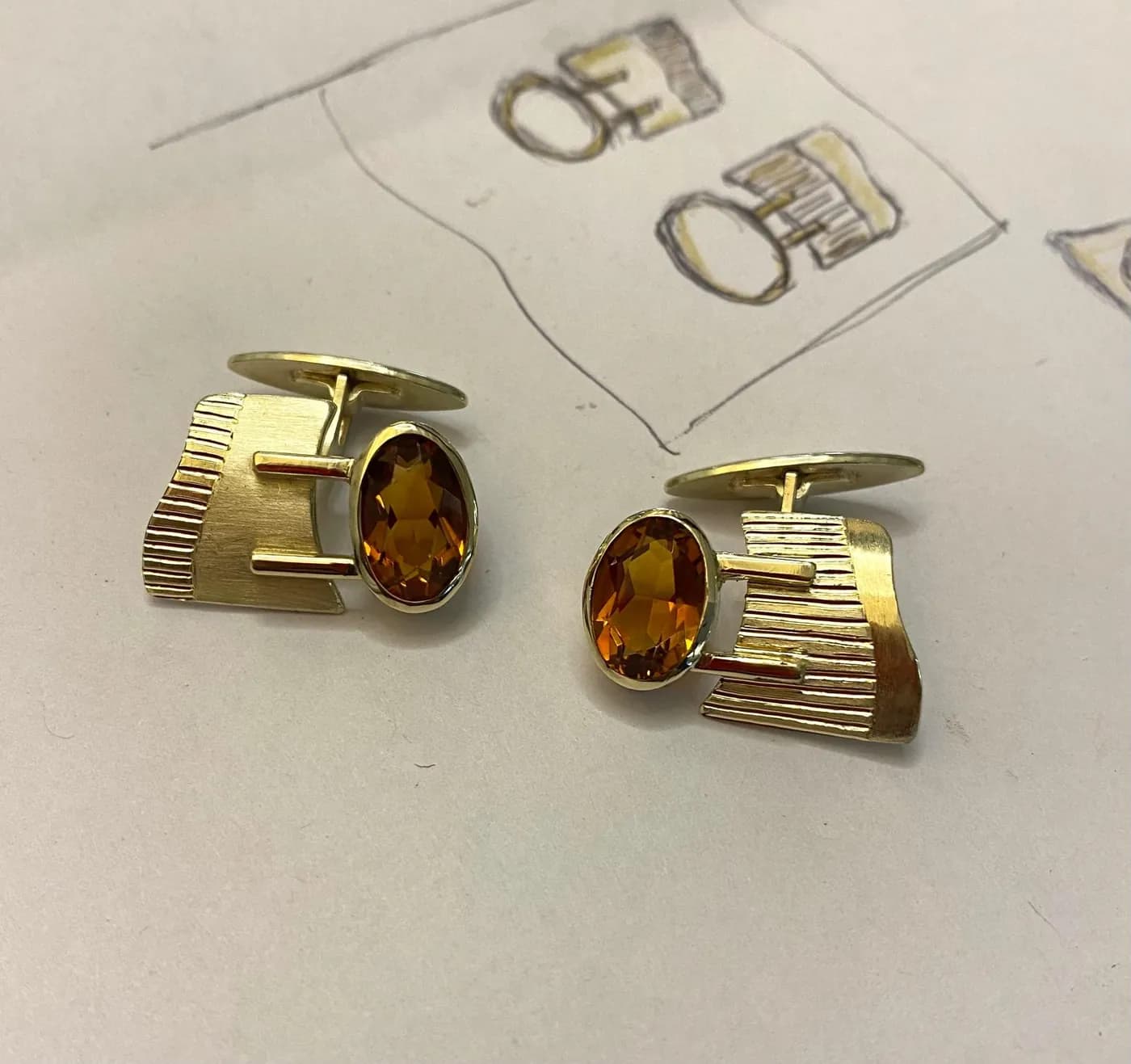 Gold cufflinks with an orange stone